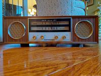 Front view showing dual speakers, tuning scale and control knobs