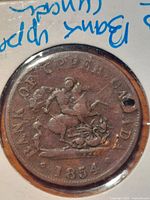 Obverse of 1854 Bank of Upper Canada one half penny token showing St. George and the dragon motif with date and bank name