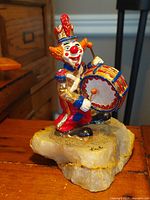 Front view of the 24K gold plated and hand painted marching drummer figurine mounted on quartz base, showing vibrant colors and detailed features