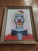 Front view of framed clown painting showing full artwork and signature