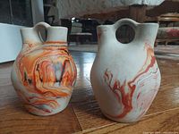 Front and side views of both Nemadji pottery vases showing unique marbled patterns and double-neck shapes.