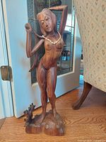 Front and slight left angle view of the carved wooden female form sculpture with beaded necklace, standing on carved wooden base.
