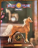 Image of catalog cover showing Breyer horse figure on a wooden clock base, marking 50 years (1950-2000) with text.