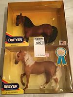Two horse models side by side in original box: brown Marabella Bay Morgan horse and light tan Gold Coast Morgan horse with original packaging and labels