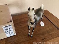 Front view of the Peter Stone Arabian Winterhawk horse figurine showing detailed facial features and original box on wooden surface.