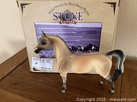 Photo of the Peter Stone Autumn Knight Arabian horse figurine in front of its original box showing front-left view.