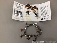 Photo showing the earrings and bracelet with the packaging card describing materials and collection