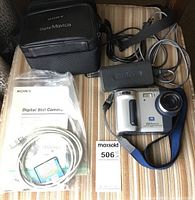 Photo showing Sony Digital Mavica camera, power adapter, USB cable, memory card, camera case, and instruction manual.
