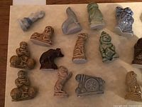 Close-up photo of various multi-colored Wade porcelain circus-themed figurines on a beige background, showing different animals and performers.