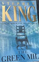 Front cover of the hardcover book 'The Green Mile' by Stephen King featuring an electric chair image