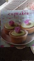 Photo of the cupcakes recipe book cover showing pink rose-decorated cupcakes.
