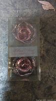 Photo showing two pink rose-shaped gel candles in clear packaging labeled Lillian Rose Long Burning.