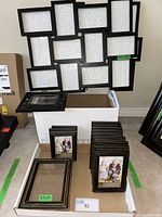 Wide view of assorted black frames including a large multi-photo frame, many small 4x6 frames, and few medium 5x7 frames