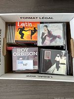 Box containing CDs including Lotin Love Affair, Sarah Brightman, Roy Orbison, and others