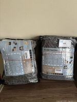 Two packaged dark gray YEMYHOM recliner covers in plastic packaging with design instructions visible.