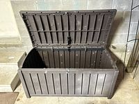 Open deck storage box showing interior and lid with support hinge.