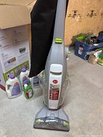 Hoover FloorMate Deluxe upright hard floor cleaner with collection bag and cleaning brush visible.