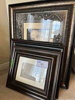 Four picture frames shown leaning together, showing ornate and dark brown frames, some with matting but no art.