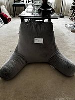 Front view of gray reading wedge pillow showing its full triangular shape with two angled arms and carrying handle at the top.