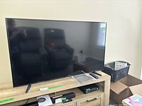 Front view of 55" Samsung TV on stand, shows entire screen and adjustable legs