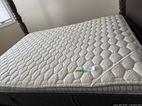 Full view of queen size mattress topper with quilted hexagonal pattern upholstery.