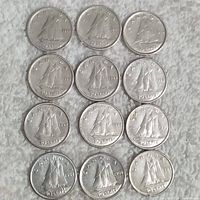 Top view of reverse sides showing Bluenose schooner and dates on 12 coins arranged in grid.