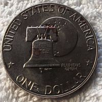 Close-up photo of bicentennial Eisenhower silver dollar coin front side, featuring Liberty Bell and Moon design with text around edges.
