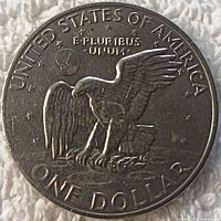 Photo showing reverse side of the 1972 Eisenhower dollar coin with eagle design, text 'UNITED STATES OF AMERICA', 'ONE DOLLAR' and 'E PLURIBUS UNUM'.