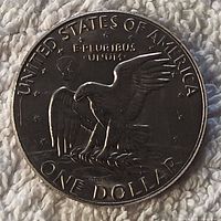 Close-up photo of the reverse side of the 1977 Eisenhower dollar coin showing the eagle design and inscriptions.