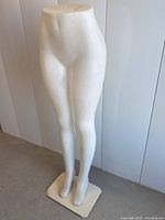 Front view of mannequin bottom half, showing attached metal stand base and full legs with feet.