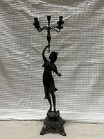 Full frontal view of figural candelabra against white backdrop