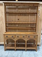 Front view of pine potboard dresser showing shelves, hooks, drawers, and bottom shelf