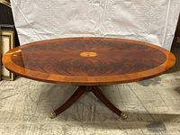Front view of oval flame mahogany table top and pedestal base, showcasing central inlay and overall shape
