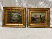 Pair of two gilt-framed oil paintings side-by-side against bubble wrap background