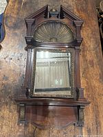 Full view of walnut framed mirror with pediment, shelf and finial