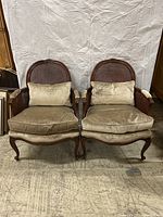 Front view of both chairs showing seat cushions, arms and caned backs.