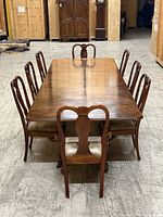 Front view of solid wood dining table with walnut veneer top and chairs (chairs not included)