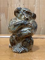 Front view of seated baboon figurine showing overall form and glaze pattern