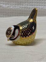 Isolated front-left angle showing detailed painting and gold gilding on the bird figurine.