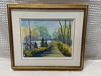 Full view of framed painting showing gold-tone frame and white mat