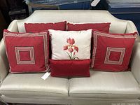 Front view of all six pillows arranged on sofa showing color, size and design variations