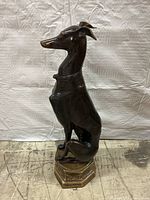 Left side view of full statue showing seated greyhound profile and hexagonal pedestal