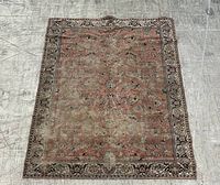 Full view of rug laid flat on floor showing overall pattern and wear