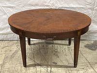Front full view of oval coffee table showing overall shape and leg style