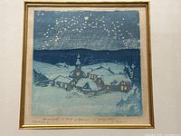 Close frontal view of framed print showing snowy village and church at night