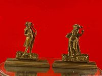 Pair of antique brass figurine bookends on cast iron bases shown together