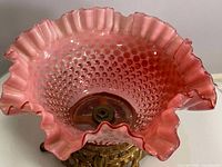 Top-down view showing the ruffled cranberry hobnail glass bowl with clear cranberry gradient and hobnail texture.