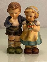 Photo showing the full view of the boy and girl Hummel figurines side by side.