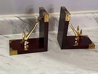 Pair of wooden bookends with solid brass anchors, showing their profile and brass corner reinforcements.