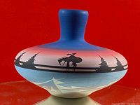 Front view of vase showing Native American figure on horseback, trees, and canoe design.